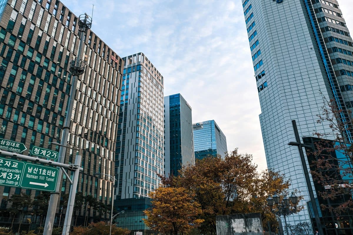 Glass office towers above a tree-lined street in central Seoul